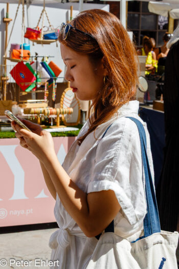Asiatin blickt auf Telefon  Lissabon Distrikt Lissabon Portugal by Peter Ehlert in LIS-LX